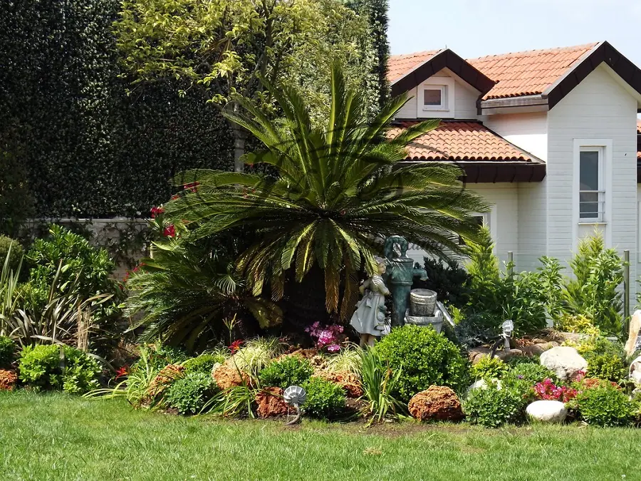Palmiyeler ve çiçek tarhlarıyla villa bahçesi